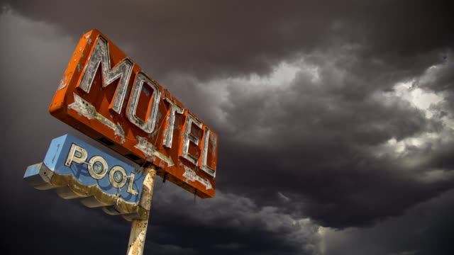Storm Gathering Over Rustic Motel Sign - Time Lapse