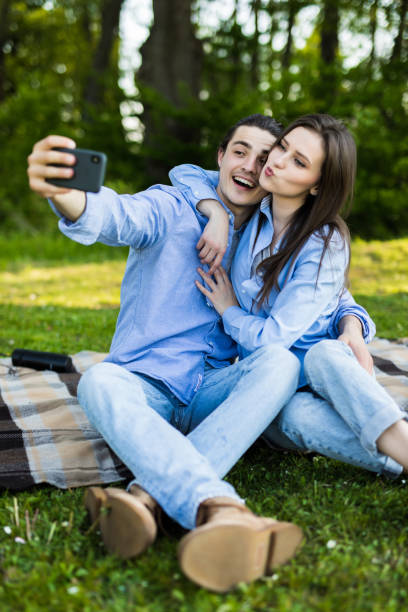 istock Young in loved couple taking selfie in park on sunny day 1253285185