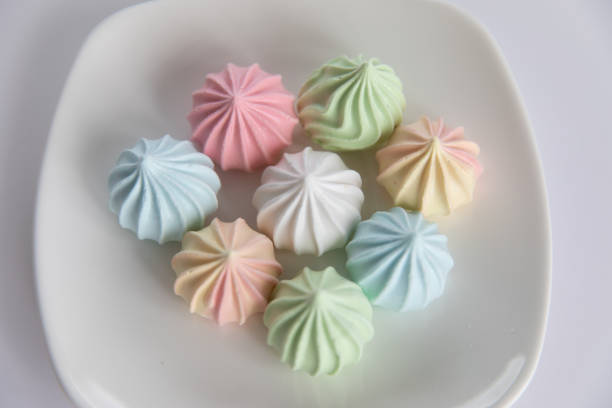 istock meringues on saucer on isolated white background. 1253285890