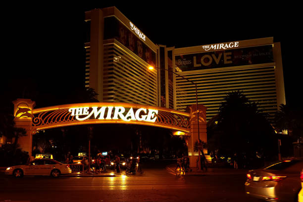 The entrance arch at the famous Mirage hotel and Casino LAS VEGAS, NV/USA - Sep 26,2018: The entrance arch at the famous Mirage hotel and Casino, lit up brightly at night on the Las Vegas Strip.The Las Vegas strip is home to most of the world's largest hotels and casinos." downtown las vegas motel sign sign commercial sign stock pictures, royalty-free photos & images