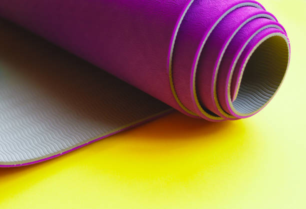 istock Bright purple yoga mat on a yellow background 1253286290
