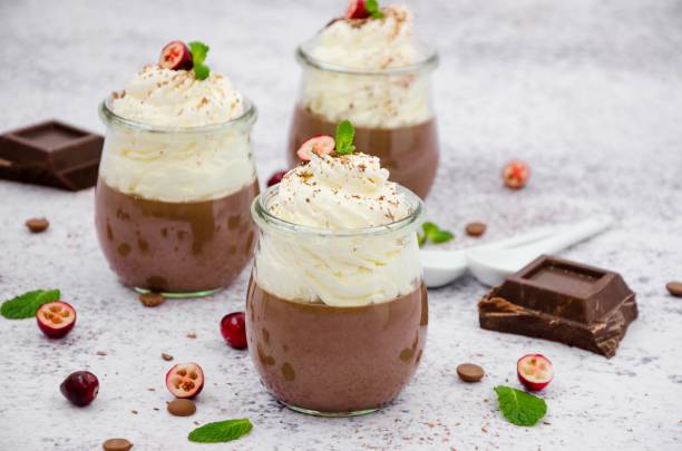 istock Chocolate cream (pudding, jelly, panna cotta) on agar agar with whipped cream on top in glass jars on a light stone background. 1253287365