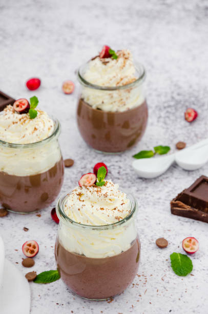 istock Chocolate cream (pudding, jelly, panna cotta) on agar agar with whipped cream on top in glass jars on a light stone background. 1253287367