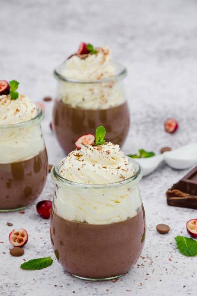 istock Chocolate cream (pudding, jelly, panna cotta) on agar agar with whipped cream on top in glass jars on a light stone background. 1253287374