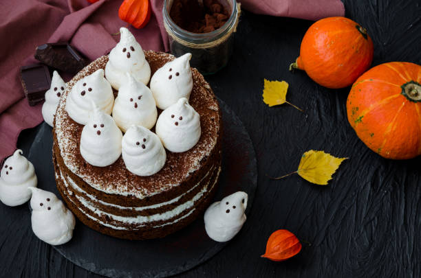 istock Halloween layer chocolate cake with white chocolate cream and meringue ghosts on top. Food idea for halloween party. 1253287676