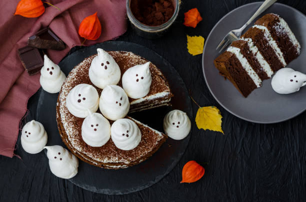 istock Halloween layer chocolate cake with white chocolate cream and meringue ghosts on top. Food idea for halloween party. 1253287679