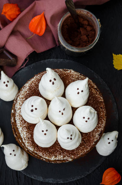 istock Halloween layer chocolate cake with white chocolate cream and meringue ghosts on top. Food idea for halloween party. 1253287736