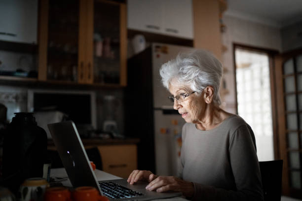 istock Senior woman using laptop home 1253287823