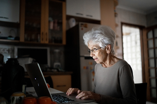 Senior woman using laptop home
