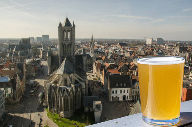 copo de cerveja belga leve contra vista de grande catedral em ghent - bruges belgium history scenics - fotografias e filmes do acervo