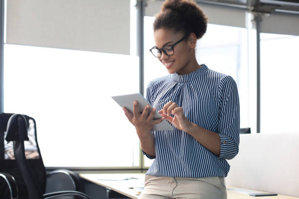 istock Beautiful business woman is working using digital tablet while sitting in creative office 1253289224