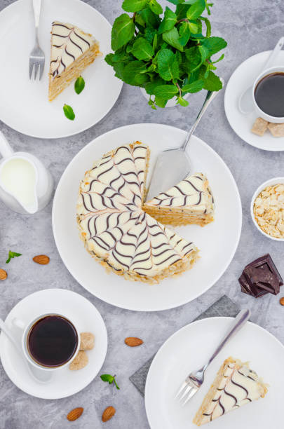 istock Traditional Hungarian Esterhazy cake on a white plate on a stone background with a cup of coffee, mint and almonds. 1253289502