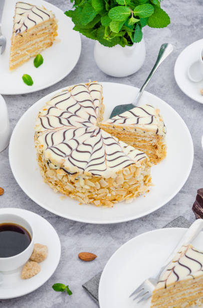 istock Traditional Hungarian Esterhazy cake on a white plate on a stone background with a cup of coffee, mint and almonds. 1253289511