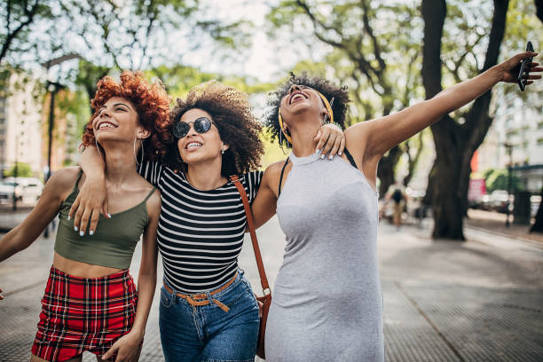 istock Three happy young women walking down the street 1253291415