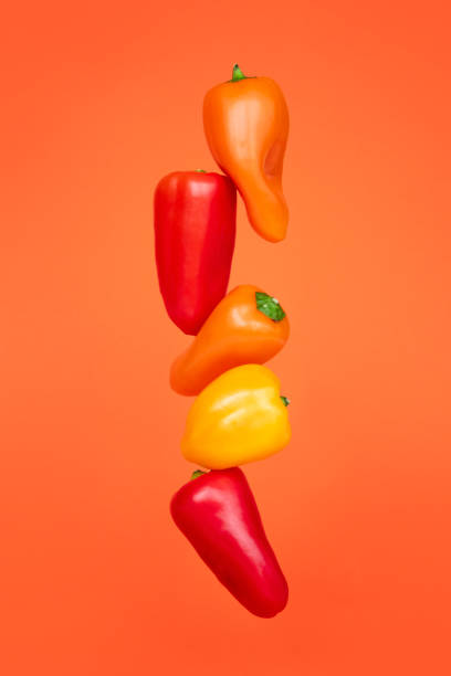 istock Colored peppers on a orange background. Cooking concept 1253294815