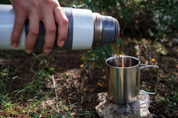 istock In a camping mug pours tea from a thermos in nature. 1253297569