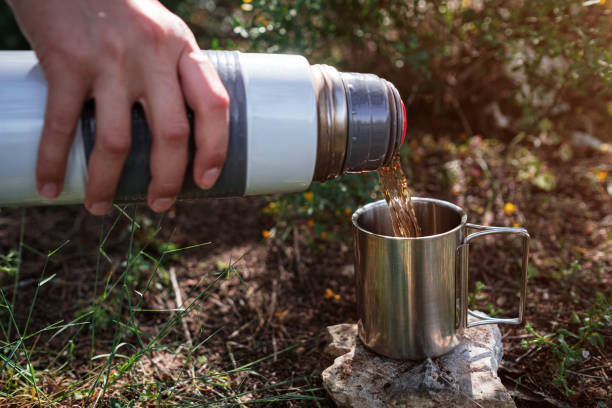 istock In a camping mug pours tea from a thermos in nature. 1253297959