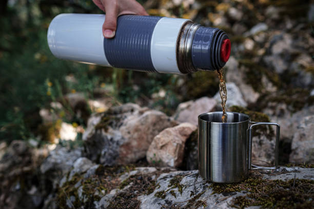 istock In a camping mug pours tea from a thermos in nature. 1253298859