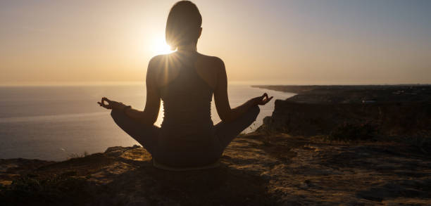 istock Young woman practicing yoga over sunset sea 1253299238
