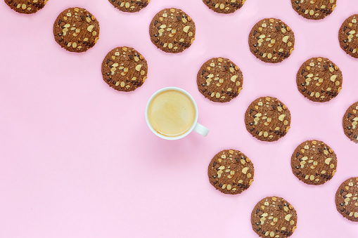 Cookies and a cup of coffee on colored background