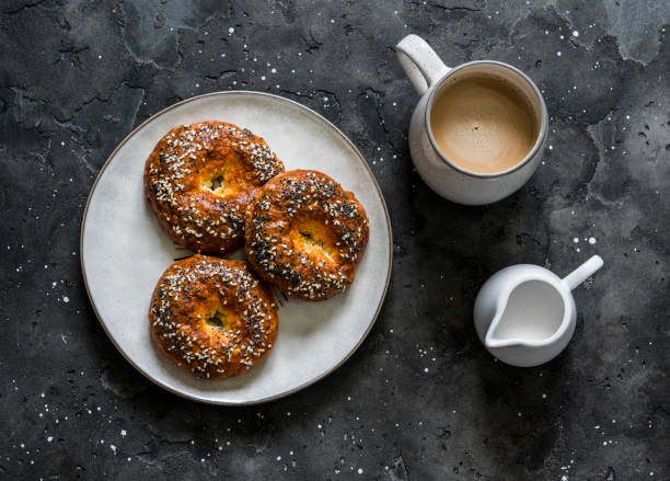 istock Savory cheese buns and coffee with cream on a dark background, top view. Delicious breakfast, brunch 1253301985