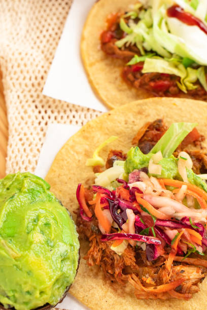 istock Mexican traditional authentic homemade tacos with pulled pork beef chili con carne serve with tomato salad and avocado guacamole and dip sauce 1253304709