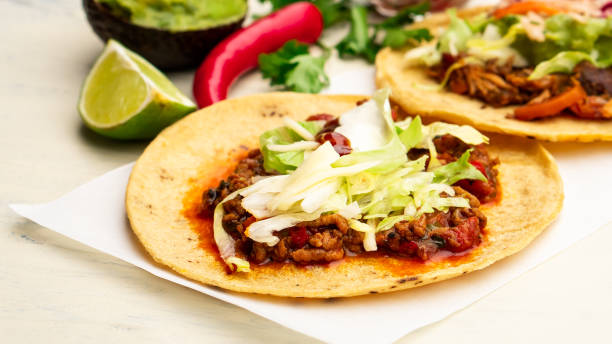 istock Mexican traditional authentic homemade tacos with pulled pork beef chili con carne serve with tomato salad and avocado guacamole and dip sauce 1253304792