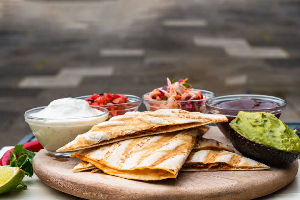 istock Mexican traditional authentic homemade quesadilla with pulled pork beef chili con carne serve with tomato salad and avocado guacamole and dip sauce 1253304974