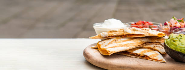istock Mexican traditional authentic homemade quesadilla with pulled pork beef chili con carne serve with tomato salad and avocado guacamole and dip sauce 1253304991