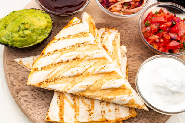 istock Mexican traditional authentic homemade quesadilla with pulled pork beef chili con carne serve with tomato salad and avocado guacamole and dip sauce 1253305195
