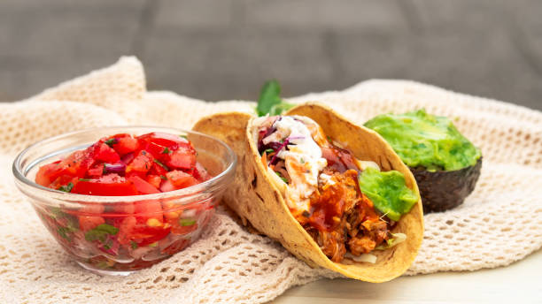 istock Mexican traditional authentic homemade tacos with pulled pork beef chili con carne serve with tomato salad and avocado guacamole and dip sauce 1253305206