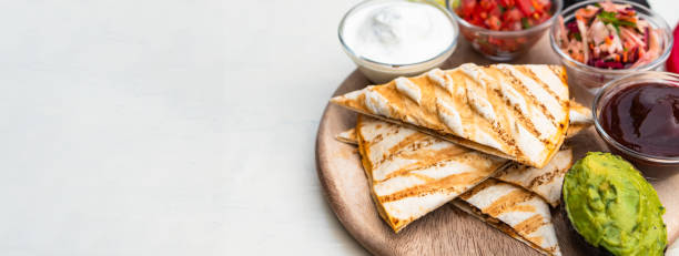 istock Mexican traditional authentic homemade quesadilla with pulled pork beef chili con carne serve with tomato salad and avocado guacamole and dip sauce 1253305212