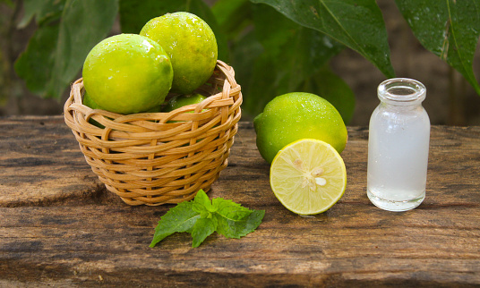 still life with lemons and lemon juice in a small glass jar on a wooden table