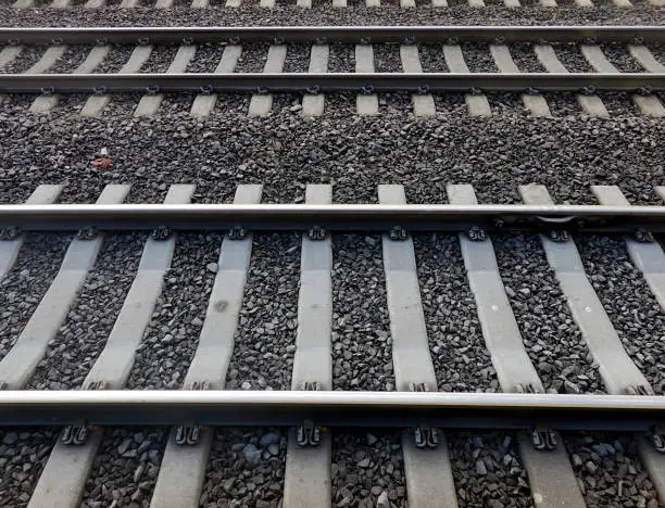 Two sets of railroad tracks with the hint of a third set of tracks.