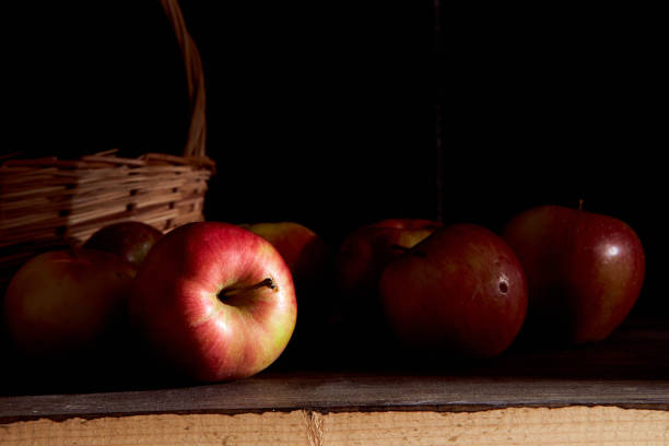 Braided basket with red apples on a black background. High quality photo