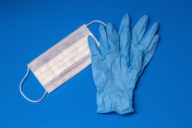 istock Medical gloves and mask for a blue background 1253308990