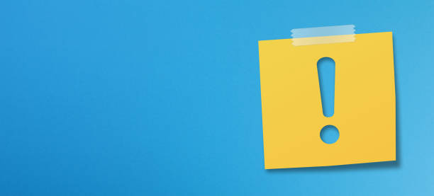 papel amarillo de la nota adhesiva con signo de exclamación sobre fondo azul - adhesive note blue sticky blank fotografías e imágenes de stock