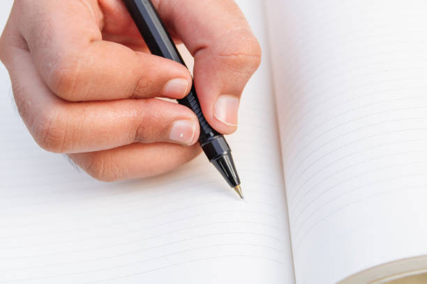 istock Hand shoot, close up portrait Hand writing on the book with a pen 1253310064