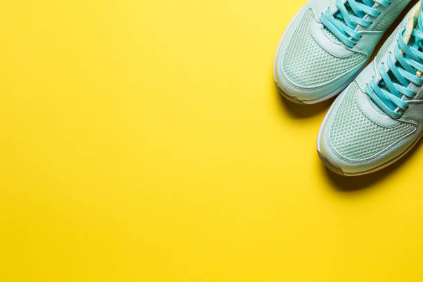 istock Turquoise sneakers with white soles on a yellow background close-up 1253312903