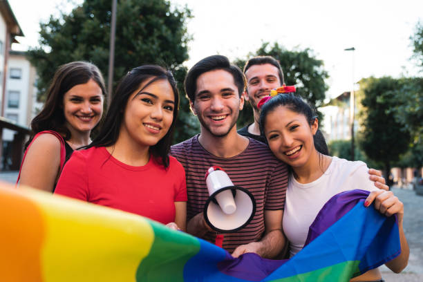 five friends together at an lgbtqi pride event - flag rainbow gay pride flag gay man imagens e fotografias de stock