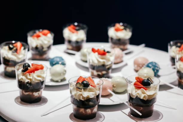 istock Desserts with whipped cream and strawberries on a white table. Glamorous style 1253320059