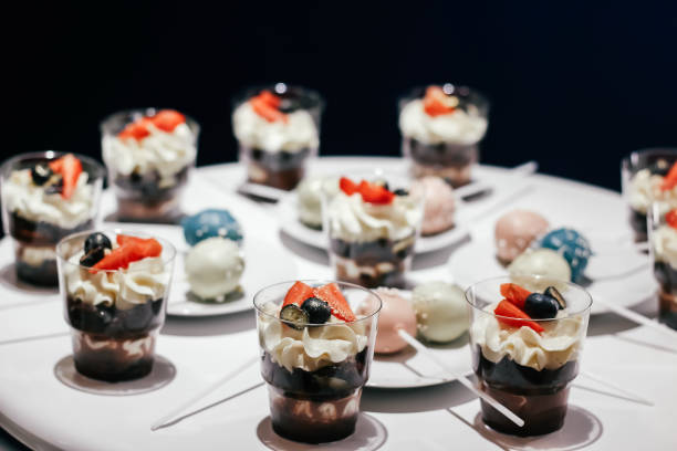 десерты со взбитыми сливками и клубникой на белом столе. гламурный стиль - victoria sandwich стоковые фото и изображения