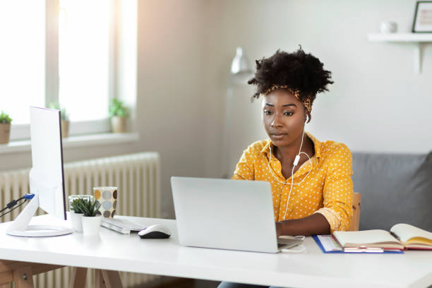 istock Woman With Headphones Working on Laptop 1253320314