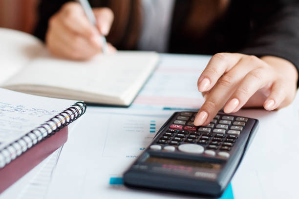 istock Businesswoman using a calculator to calculate the numbers 1253323096