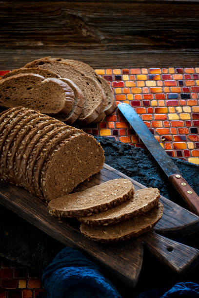 Wholegrain rye bread loaf on cutting board with vintage knife