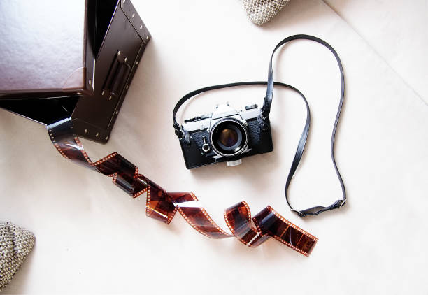 vintage film rangefinder camera with leather case and photographic film on light colored background. - rangefinder camera imagens e fotografias de stock