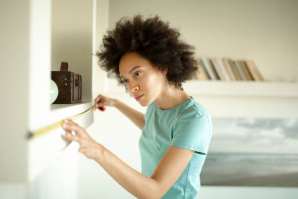 istock Female interior designer taking measurements at home 1253330539