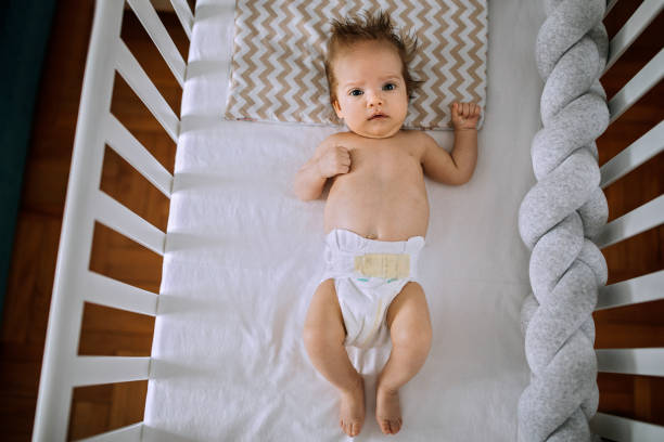 istock Cute baby boy lying in his crib 1253331655