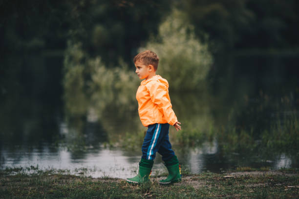 istock A boy in rubber boots walks by the river 1253337526