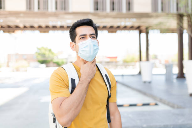 istock Man With Throat Pain Wearing Mask 1253340103